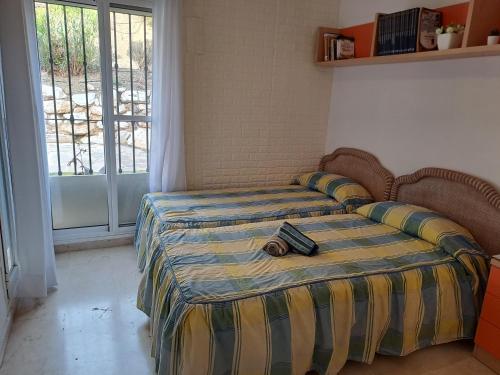 um quarto com uma cama com um par de sapatos em Bienvenido a tu habitacion em Málaga