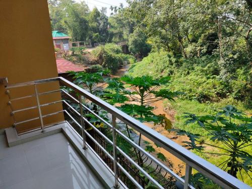 a balcony with a view of a forest at D'more Sreemangal Hotel & Resort in Sreemangal