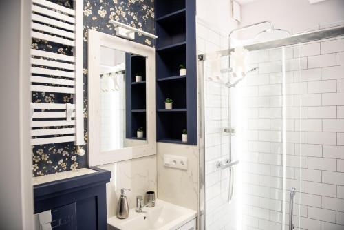 a bathroom with a sink and a mirror and a shower at Pensjonat Kaja in Rymanów-Zdrój