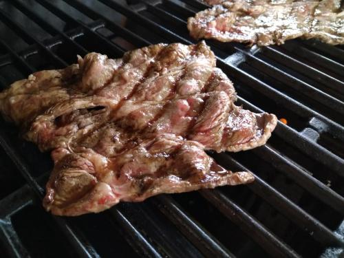 two pieces of meat cooking on a grill at 大人数の家族旅行に！BBQ(夏)/雪遊び(冬)/しゃぶしゃぶの鍋/カラオケ/Switch/映画も！ in Kami-furano