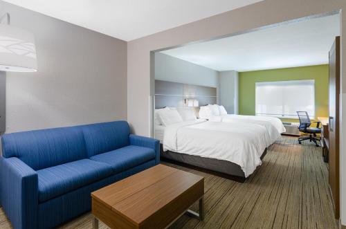 a hotel room with a bed and a blue couch at Holiday Inn Express Hotel & Suites Weston, an IHG Hotel in Weston