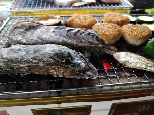 two fish and donuts on a grill with food at 大人数の家族旅行に！BBQ(夏)/雪遊び(冬)/しゃぶしゃぶの鍋/カラオケ/Switch/映画も！ in Kami-furano