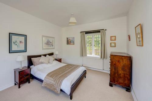 um quarto branco com uma cama e uma janela em NEW - Beautiful, spacious Beechwood Lodge with lovely gardens em Chalfont Saint Giles