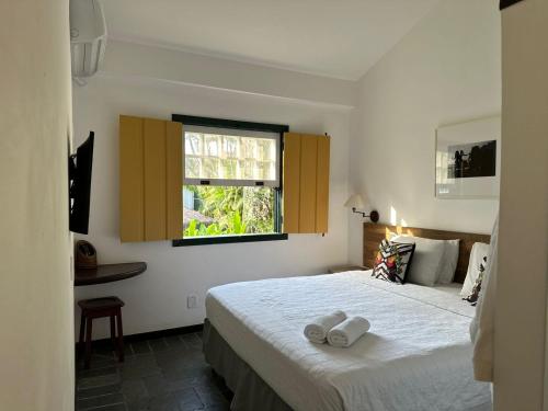 a bedroom with a bed with two towels on it at Pousada do Príncipe in Paraty