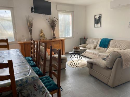 a living room with a couch and a table at Les Oiseaux Résidence 