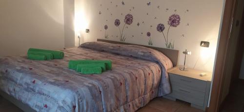 una camera da letto con un letto con due cuscini verdi di Casa da Mary a Iseo