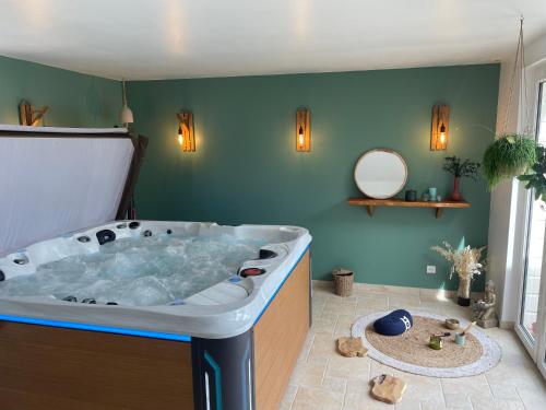Cette chambre comprend une salle de bains pourvue d'une grande baignoire. dans l'établissement Maison de charme, à Yvetot Bocage