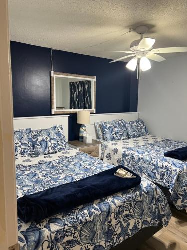 1 dormitorio con 2 camas y ventilador de techo en Ponce de Leon Towers, en New Smyrna Beach