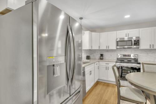 a kitchen with a stainless steel refrigerator and a table at Single Story Pet Friendly Home, with Fenced Yard, Fire Pit, 5min to Downtown!! in Nashville
