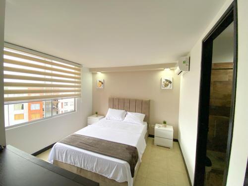 a small bedroom with a bed and a window at Apartamento en Pereira in Pereira