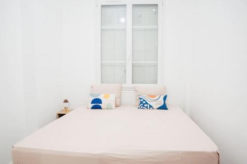 un letto bianco in una stanza con una finestra di Appartement Cosy près de Paris et Disney a Neuilly-Plaisance