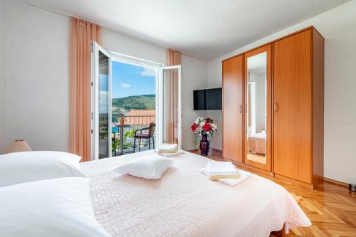 um quarto com uma grande cama branca e uma janela em Sea View, Free Parking 2br Apartment em Dubrovnik