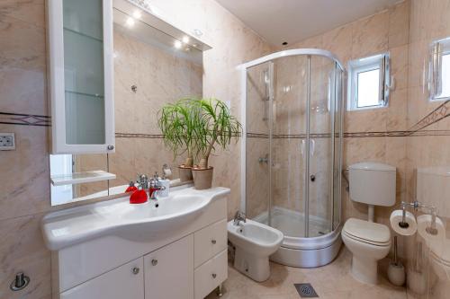 uma casa de banho com um lavatório, um chuveiro e um WC. em Sea View, Free Parking 2br Apartment em Dubrovnik
