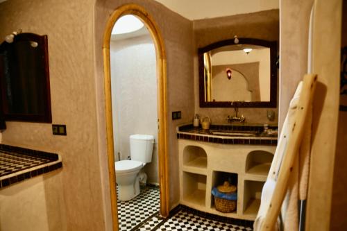 y baño con lavabo, aseo y espejo. en Riad Desert Man en Merzouga