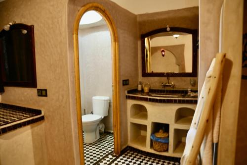 a bathroom with a sink and a toilet and a mirror at Merzouga Riad Desert Man in Merzouga