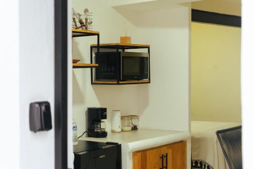 a kitchen with a counter with a microwave on the wall at Casa Don José: GIRASOLES Suite in Oaxaca City