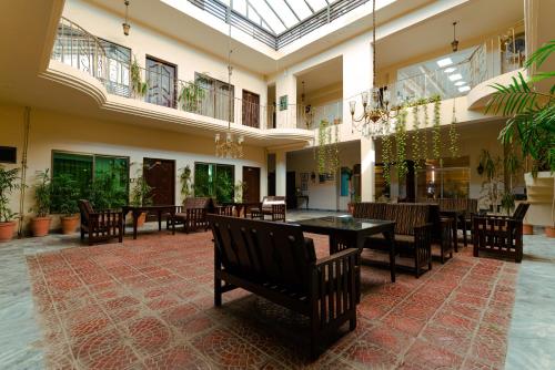 una sala da pranzo con tavoli e sedie in un edificio di Shelton Rezidor House Peshawar a Peshawar