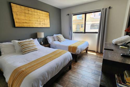 圣米格尔-德阿连德Mateo place ideal for your next visit to San Miguel的有两张床和一扇窗户的酒店房间