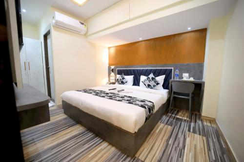 a hotel room with a bed and a desk at N.M. Hotel in Mumbai