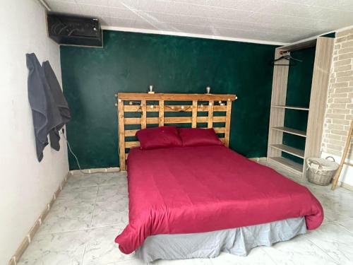 um quarto com uma cama vermelha e uma parede verde em Le Ranch - proche centre ville em Reims