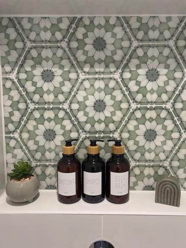 three bottles of liquid sitting on a shelf in a bathroom at Luxurious and Peaceful Lakeside House, Clitheroe in Clitheroe