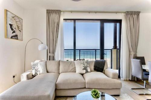 a living room with a couch and a large window at Ocean Majestic Full Sea View at Le Pont in Dubai