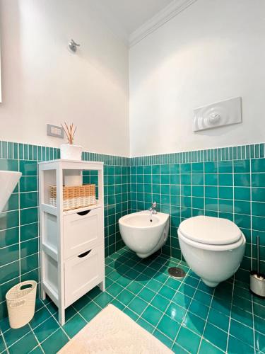 baño de azulejos azules con lavabo y aseo en Glory House Trastevere, en Roma