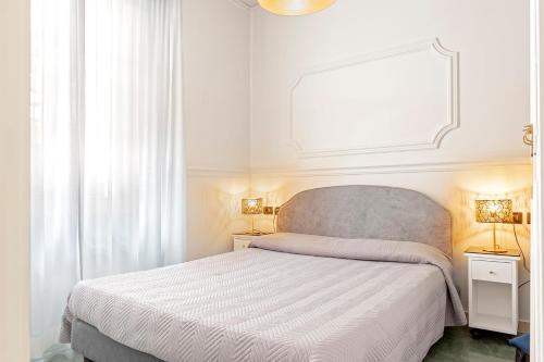 una camera bianca con un grande letto e due lampade di The Port Residence a Livorno