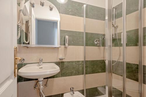 La salle de bains est pourvue d'un lavabo et d'une douche. dans l'établissement The Port Residence, à Livourne