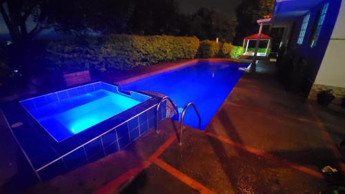 卡拉爾卡的住宿－Kai Hotel Campestre，夜晚的游泳池,拥有蓝色的灯光