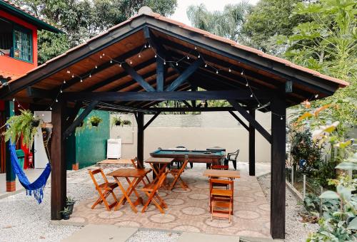 um pavilhão de madeira com uma mesa e cadeiras em Sagui Hostel em Florianópolis
