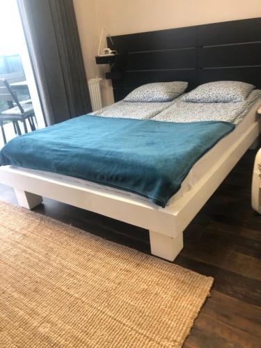 een bed met een blauwe deken erop in een kamer bij Kawalerka na Targowej in Toruń