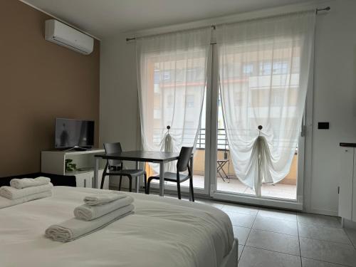 a bedroom with a bed and a table and a window at APPARTAMENTO FIERA MILANO - Affitti brevi Italia in Pero