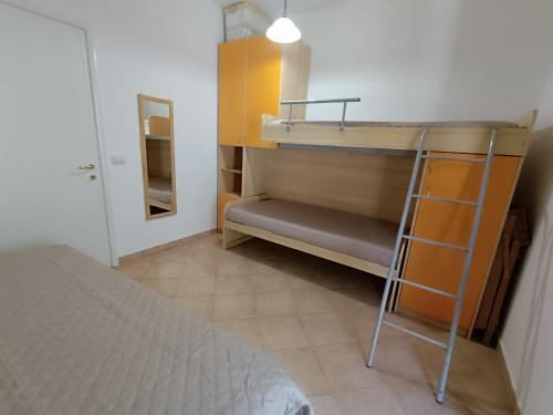 Al Porto, casa vacanze 100mt dal mare في مارينا بورتو: غرفة صغيرة مع سرير بطابقين وسلم