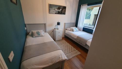een kleine slaapkamer met 2 bedden en een raam bij Greystone House in Achill