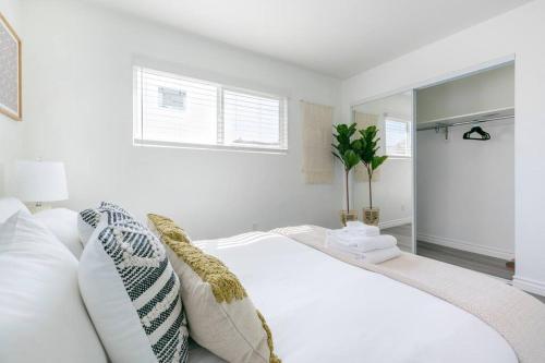 a white bedroom with a white bed and a window at Enjoy Alhambra Night Life at 2BR Apt in Alhambra