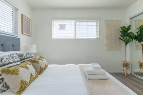 a white bedroom with a large bed and a window at Enjoy Alhambra Night Life at 2BR Apt in Alhambra