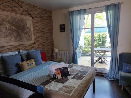 une chambre avec un lit et une porte coulissante en verre dans l'établissement La Clef du Bonheur - 9 Min de Disney Jardin privatif, à Bailly-Romainvilliers