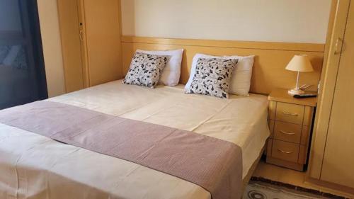 een slaapkamer met een groot wit bed met 2 kussens bij Piemonte Flat Serra Negra in Serra Negra