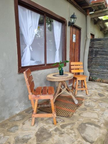 a patio with a table and chairs and a window at Kite Eco House Salinas del rey in Salina de Rey