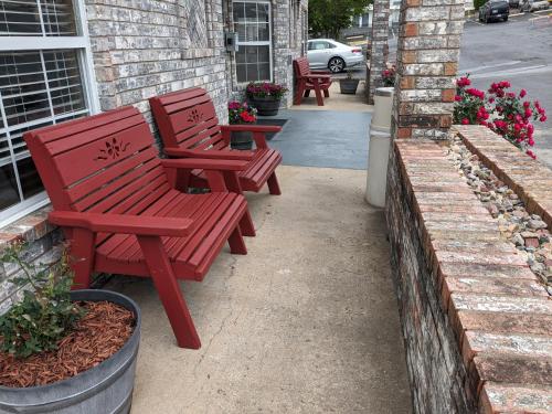 two red benches sitting outside of a building at Dutton Inn in Branson