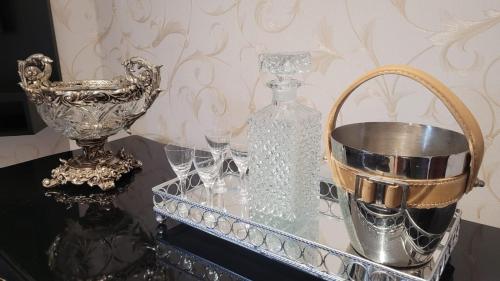 Una mesa con vasos y una botella y una cesta. en Apartamento flat em Serra Negra - 12A, en Serra Negra