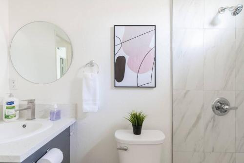 a bathroom with a toilet and a sink and a mirror at City Retreat Minutes to DT in Alhambra