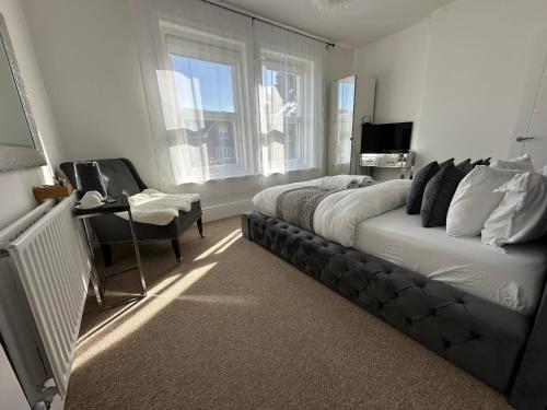 um quarto com uma cama, uma secretária e uma janela em 5 min from the beach En suite room in Guest house em Bournemouth