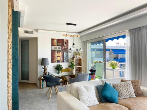 un salon avec un canapé et une salle à manger dans l'établissement Plage et hippodrome. Parking, à Cagnes-sur-Mer