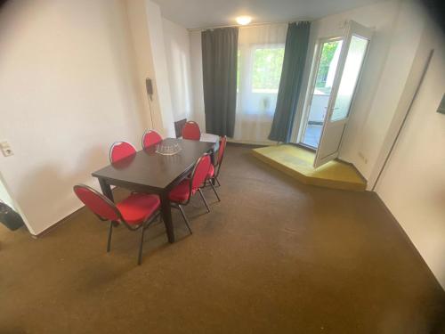 a dining room with a table and red chairs at Kapitän Dallmann str.14 in Bremen