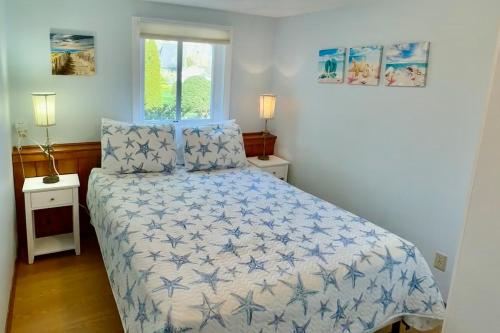 a bedroom with a bed with a blue and white comforter at Birch Circle Beach House in Ogunquit