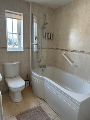 Higham Ferrersにある3 Bed. Sleeps 5. Higham Ferrers. Free Car Charger.のバスルーム(白いバスタブ、トイレ付)