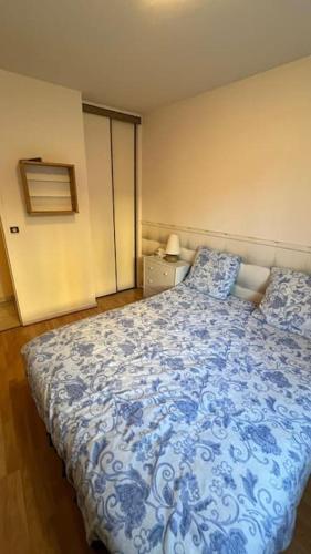 une chambre avec un lit bleu et blanc dans l'établissement Appartement avec deux couchages, à Triel-sur-Seine