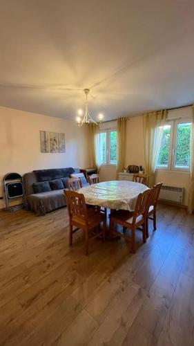 un salon avec une table, des chaises et un canapé dans l'établissement Appartement avec deux couchages, à Triel-sur-Seine
